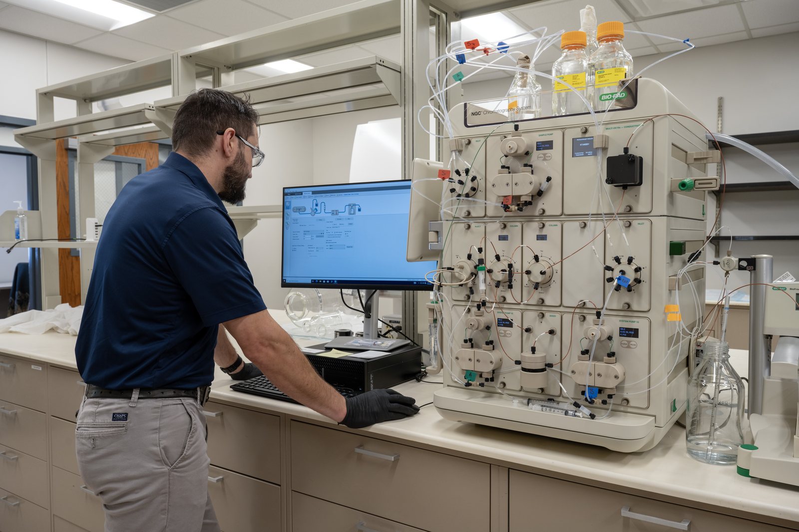 An ETSU Research Corporation scientist operating the FPLC chromatography purification system in the Valleybrook downstream suite