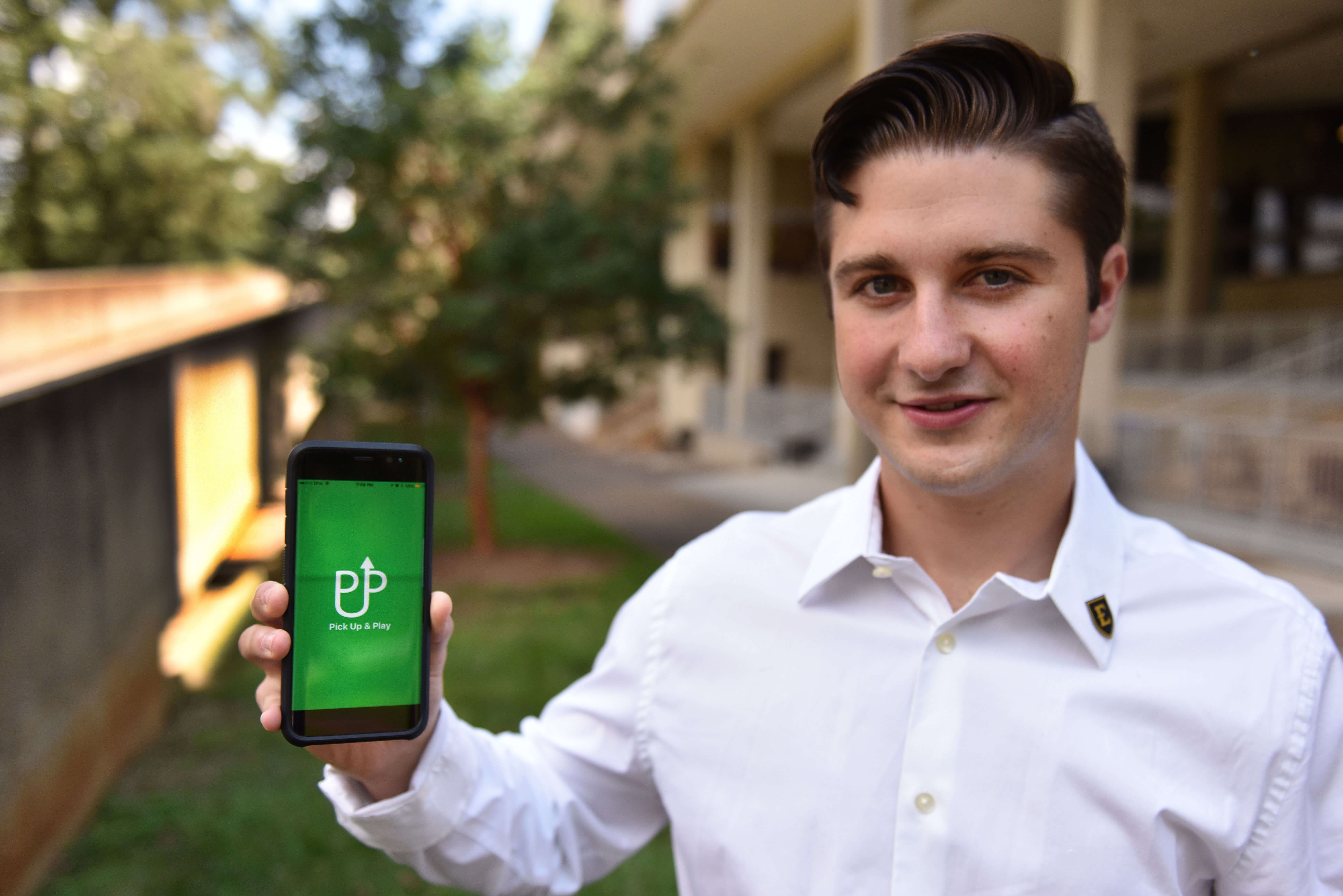Arshene Baigvand holds phone up, showing pick up and play. He is the iBUCS Winner and Creator of Pick Up & Play.